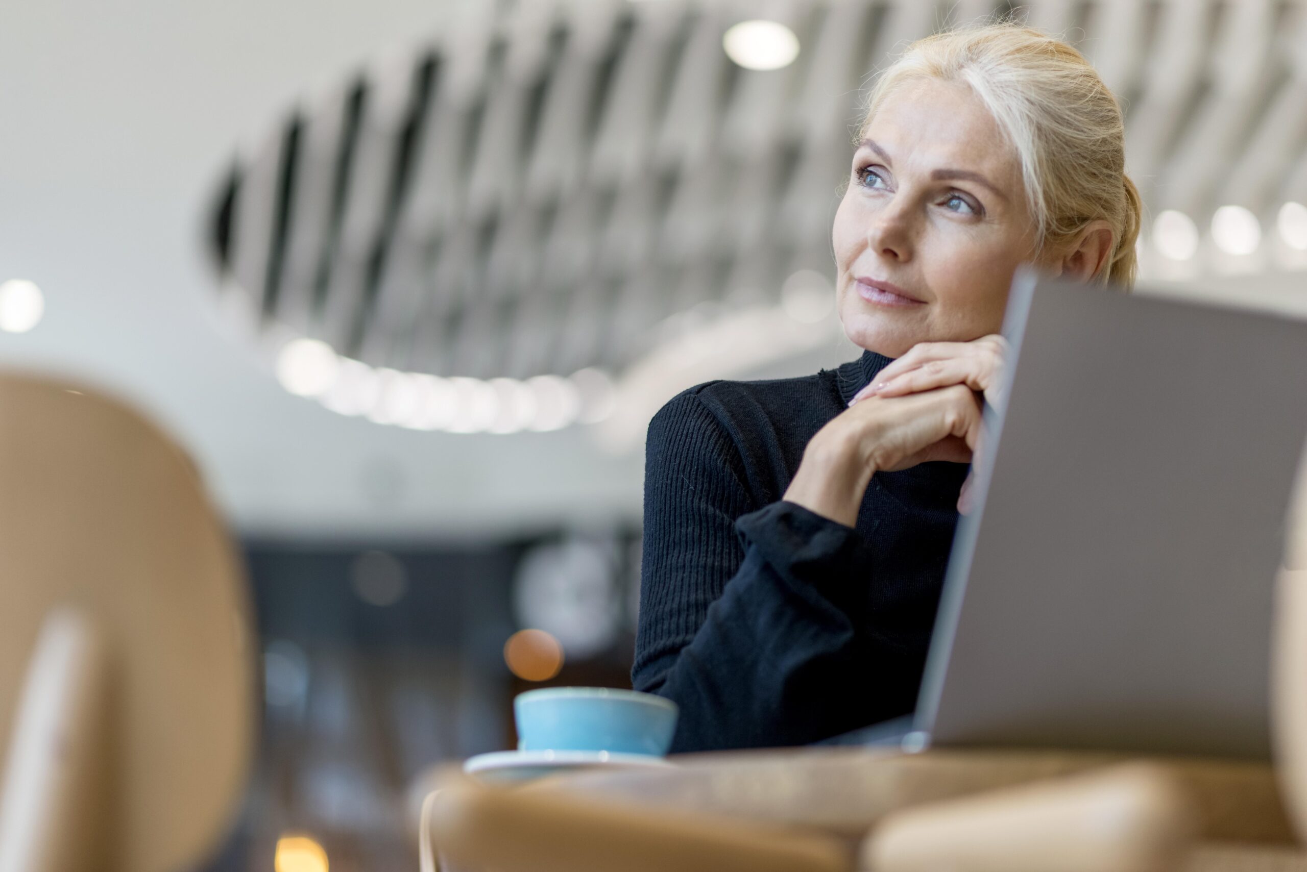 eldre dame som sitter på kafe og jobber